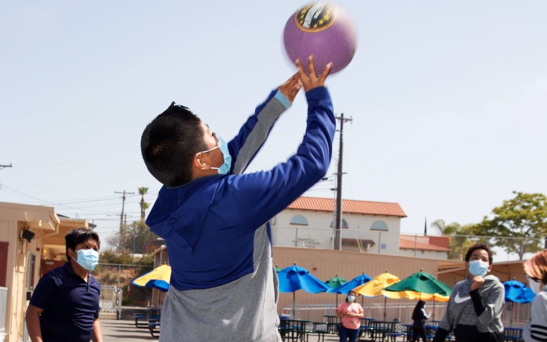 Empower Language Academy students play basketball on the outdoor playground