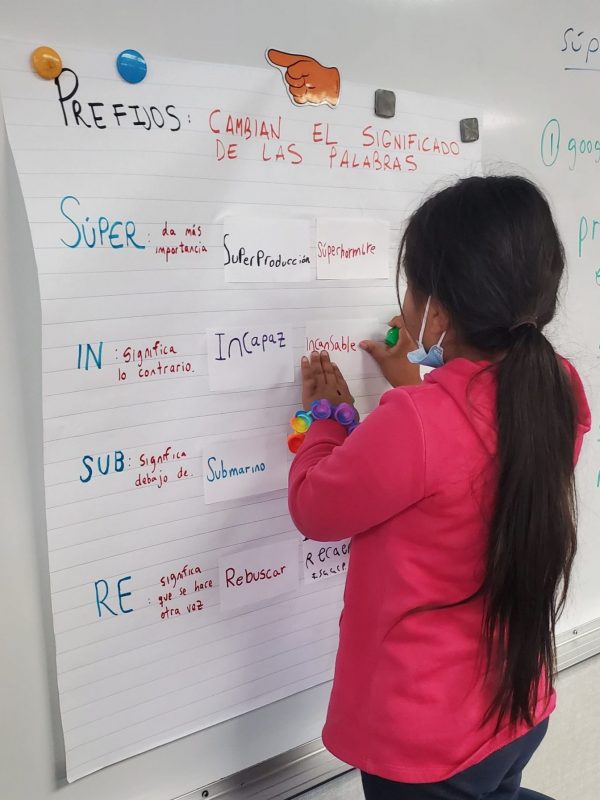 Student working on white board<br />
