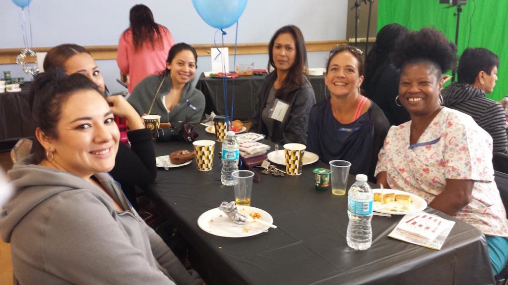 6 parent volunteers at Empower Langauge Academy smile during a volunteer celebration